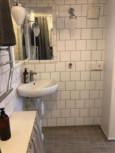 y baño con lavabo y espejo. en Lägenhet i Rosa Villan anno 1917 en Stallarholmen
