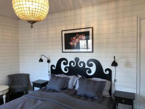 a bedroom with a large bed and a chandelier at Lägenhet i Rosa Villan anno 1917 in Stallarholmen +39 photos