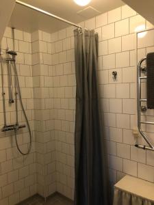 een douche met een douchegordijn in de badkamer bij Lägenhet i Rosa Villan anno 1917 in Stallarholmen