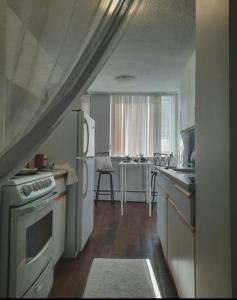 a kitchen with white appliances and a table in the window at West Edmon. Mall = Room in Edmonton