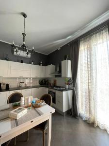 a kitchen with white cabinets and a table and a window at La Baronessa in Palermo