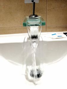 a faucet with water coming out of a sink at Hostel Boutique Marisol in Monte Gordo