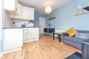 cocina y sala de estar con sofá y mesa en Clonbur House - One bedroom apartment en Galway