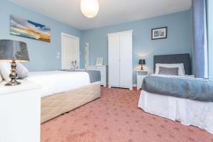 two beds in a bedroom with blue walls at Clonbur House - One bedroom apartment in Galway