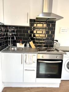 a kitchen with a stove and a sink at Very Nice Studio Flat in a Great Location in London