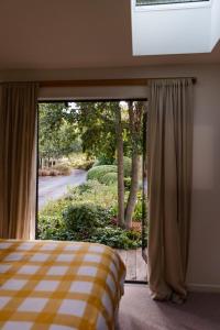 um quarto com uma cama e uma grande janela em Seedlings - at Verve flower farm em Wairau Valley