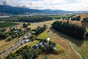 an aerial view of a farm with trees and a river at Seedlings - at Verve flower farm in Wairau Valley