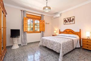 ein Schlafzimmer mit einem Bett, einem Fernseher und einem Fenster in der Unterkunft Casa Los Cortijillos in Alcaucín + 54 Fotos