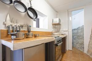 eine Küche mit einer Theke mit Töpfen und Pfannen darauf in der Unterkunft Casa Los Cortijillos in Alcaucín