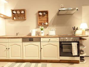 a kitchen with white cabinets and an oven at Poggenhagen Urlaub mitten in der Natur in Neustadt am Rübenberge