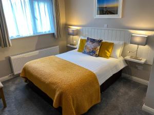 a bedroom with a large bed with yellow pillows at Sraid Eoin House in Dingle