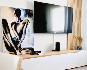 una sala de estar con TV en un armario blanco en Arrábida Cozy House, en Palmela