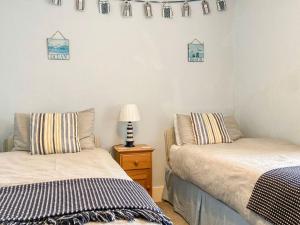 una camera con due letti e una lampada su un tavolo di Dolphin Cottage a Braunton