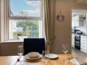 tavolo da pranzo con bicchieri da vino e finestra di Dolphin Cottage a Braunton