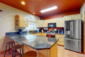 cocina con encimera grande y nevera en Bello Lago Villa, en Pagosa Springs