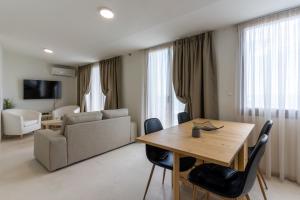 a living room with a table and a couch at White Pearl Apartments in Paralia Katerinis