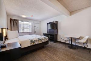 um quarto de hotel com uma cama, uma secretária e uma mesa em Studio 6 Rock Springs WY Flaming Gorge em Rock Springs
