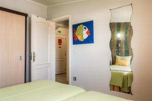 a bedroom with a bed and a mirror on the wall at HC Torreira Beach in Torreira