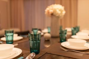 einen Tisch mit weißen Tellern und Gläsern darauf in der Unterkunft Basha Apartment PREMIUM Sopot 1 in Sopot