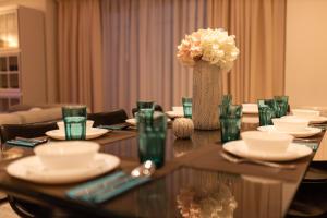 a long table with plates and a vase of flowers at Basha Apartment PREMIUM Sopot 1 in Sopot