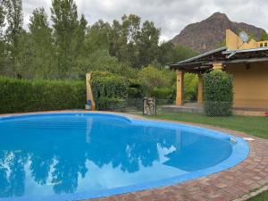 a large blue swimming pool in a yard at Chalet Ailinco in Valle Grande