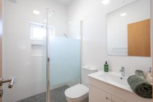 baño blanco con aseo y ducha acristalada en Casa 7 Gerações, en Sagres 32 fotos más