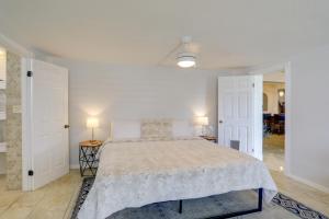 a white bedroom with a large bed and two lamps at Waterfront Home with Game Room, 2 Miles to Beach! in Seminole