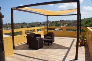 a patio with two chairs and a canopy on a roof at The Vista Inn in Falmouth