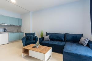 a living room with a blue couch and a table at White Pearl Apartments in Paralia Katerinis