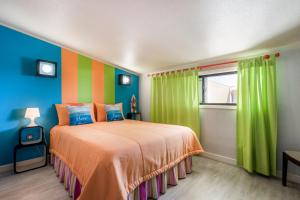 a bedroom with a bed with colorful walls and a window at HC Torreira Beach in Torreira