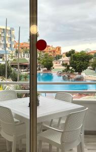 a white table and chairs with a view of a pool at Dreams vacation tenerife in San Miguel de Abona