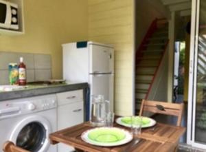 a kitchen with a table with a washing machine at Maison colibri in Les Anses-dʼArlets