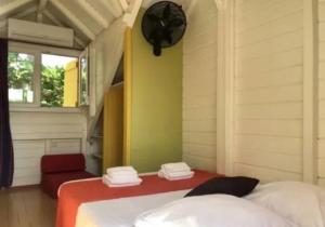 sypialnia z 2 łóżkami i oknem w obiekcie Maison colibri w mieście Les Anses-d'Arlet