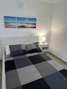 ein Schlafzimmer mit einem schwarz-weiß karierten Bett in der Unterkunft Dreams vacation tenerife in San Miguel de Abona