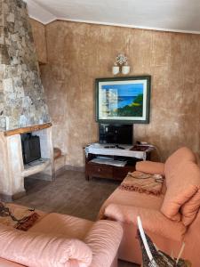 a living room with a couch and a tv at Villa Rocce Rosse in Costa Paradiso