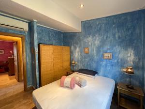 a bedroom with a bed and a blue wall at Villa Rocce Rosse in Costa Paradiso