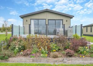 une maison avec un jardin en face dans l'établissement Midsomer Lodges, à Pilton