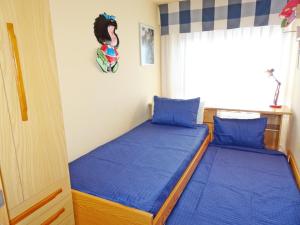 dwa łóżka w sypialni z niebieską pościelą i oknem w obiekcie AQUARIUM playa de Gandía - ( Alquiler solo familias ) w mieście Playa de Gandia