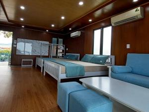 1 dormitorio con 2 camas, sofá y TV en Chunlii Homestay en Ke Ga