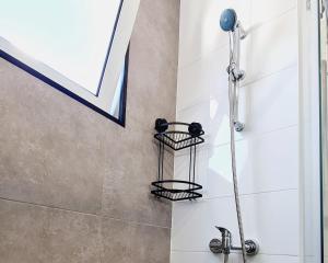 a bathroom with a shower with a shower head at Arrábida Cozy House in Palmela