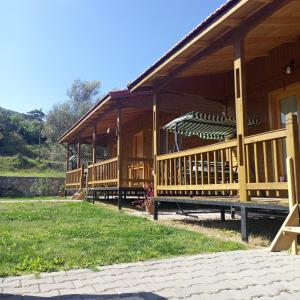 a large wooden house with a large deck at Fidelya Bungalow Evleri in Adrasan