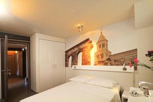 1 dormitorio con 1 cama y una foto de una iglesia en La Porta Luxury Rooms, en Split