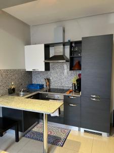 a kitchen with gray cabinets and a counter top at Jolie appartement avec piscine in Agadir