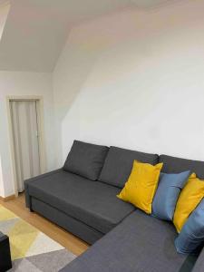 - un canapé gris avec des oreillers jaunes et bleus dans le salon dans l'établissement Home Lisbon 1, à Lisbonne