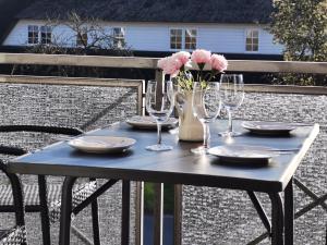 una mesa con vasos, platos y flores. en Schaake Hooksiel zum Wohlfühlen, en Hooksiel