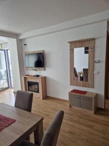 a living room with a table and a mirror at Gondola Neda Lux in Zlatibor