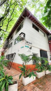 a white building with plants in front of it at Vintage House With Jacuzzi In Manila in Medellín