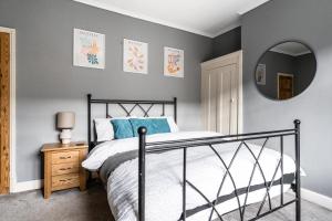 a bedroom with a black bed and a mirror at Merton House - Entire Modern City Centre Home in Leicester