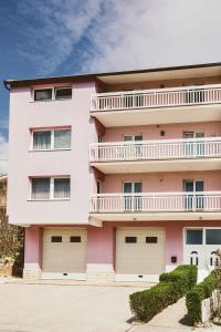 a pink apartment building with a balcony at Luxury Apartment Leonarda on the river Vrljika in Imotski