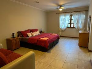 Un dormitorio con una cama con sábanas rojas y una ventana en Gran Casa del Centro Mendoza City en Mendoza